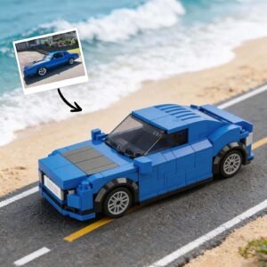 Customizable blue toy car built with blocks, placed on a road with a beach background. A photo of the real car is shown above with an arrow pointing to the block version.