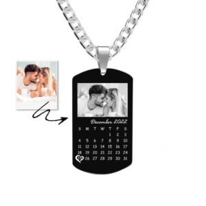 Personalized black dog tag necklace with engraved photo and calendar design, featuring “December 2022” and a highlighted date, on a silver chain.