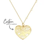 Gold heart necklace with custom map-style engraving, labeled “Custom place or address,” on a delicate chain against a white background.