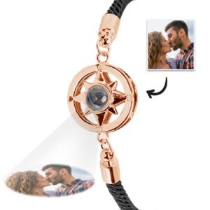 A rose gold compass-themed bracelet with a central projection element, displaying a customizable engraved photo below the pendant of a couple