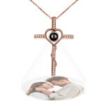 Personalized rose gold cross pendant necklace with heart-shaped detail, featuring a hidden photo projection of a couple embracing, displayed on a chain.