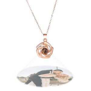 Rose gold heart-shaped pendant necklace with a black projection stone displaying a custom photo of a couple kissing, floating below the pendant.