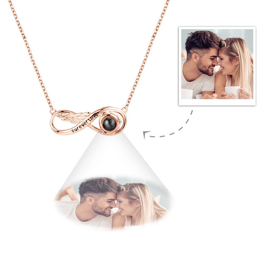 GPNL1177jpg - Printshop4me.au A rose gold infinity-shaped pendant necklace featuring a central black projection element and the engraving "Forever Love," displaying a customizable engraved photo below the pendant of a couple touching foreheads and smiling while holding coffee cups.