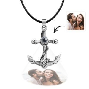 A silver anchor-shaped pendant necklace with a black cord, featuring a projection element at the center, displaying a customizable engraved photo below the pendant of a couple smiling and laughing together.