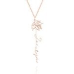 A delicate rose gold necklace featuring a slender chain and a palm tree shaped pendant with a vertical script name hanging below it.
