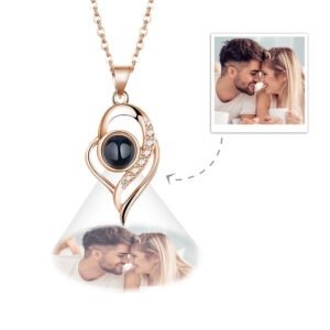 TGPNL1137jpg - Printshop4me.au Rose gold heart-shaped necklace with a black stone and small crystals, projecting a photo of a smiling couple, shown with original couple image inset for personalization.
