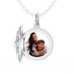 Silver round locket necklace opened to show a custom photo of a smiling couple, with the locket hanging from a chain