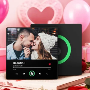 Personalized custom photo music plaque featuring a couple smiling and leaning close, with the woman wearing a knit winter hat, displayed in a Spotify-style music player design for the song “Beautiful” by Giulio Cercato. The interface includes a progress bar, playback controls, and a heart icon. The plaque is set in a romantic pink-themed background with heart decorations, gift boxes, and a black secondary panel with a green circular record-style element.