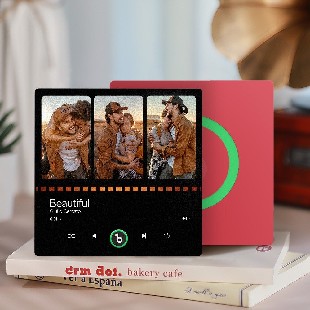 BXT0P1319X12jpg - Printshop4me.au Personalized custom photo music plaque featuring a three-photo collage of a couple hugging and smiling in warm outdoor lighting, displayed in a Spotify-style music player interface for the song “Beautiful” by Giulio Cercato. The design includes a progress bar, playback controls, and a green circular record-style element on a red background panel behind the plaque. The scene is styled as a cozy tabletop setup with books beneath and soft home décor in the background.