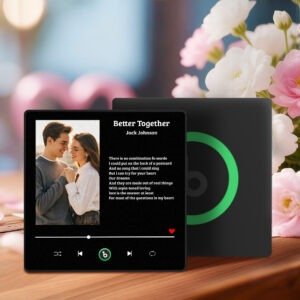 Personalized custom photo music plaque titled “Better Together” by Jack Johnson, featuring a couple holding hands in a warm portrait on a Spotify-style black interface. The design includes song lyrics displayed on the right side, a progress bar and playback controls at the bottom, and a small heart icon. The plaque is set in a romantic indoor scene with flowers in the background and a secondary black panel with a green circular record-style element behind it.