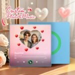BXT0P744X16jpg - Printshop4me.au Personalized custom photo and music plaque featuring a couple’s photo inside a heart-shaped frame on a soft pink gradient background, surrounded by floating red heart icons. The design displays the song “Beautiful” by Giulio Cercato in a music code-style music player interface with playback controls and progress bar. The top includes the text “Custom Photo & Music.” A second blue panel with a green circular record-style design is placed behind the plaque in a romantic indoor setting.
